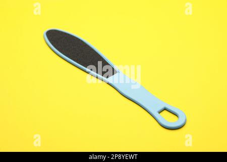 Light blue foot file on yellow background. Pedicure tool Stock Photo