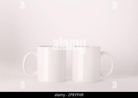 Blank white ceramic mugs on light background Stock Photo