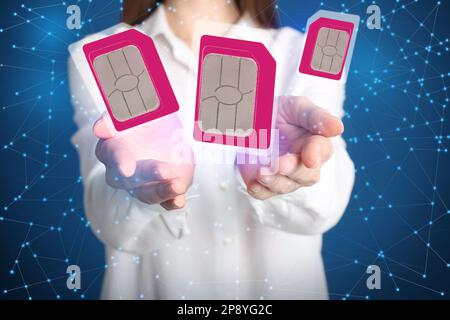 Woman demonstrating SIM cards of different sizes on color background, closeup Stock Photo