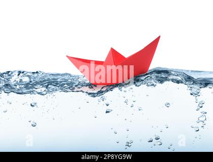 Handmade red paper boat floating on clear water against white background Stock Photo