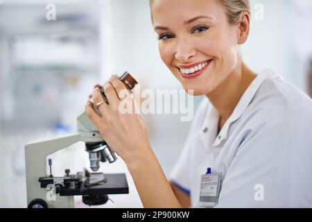 Life through the lens. a beautiful woman in a laboratory working with a microscope. Stock Photo