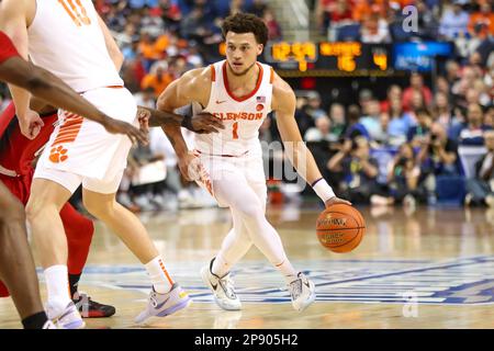 GREENSBORO, NC - MARCH 09: Chase Hunter (1) of the Clemson Tigers defends Jack  Clark (5) of the North Carolina State Wolfpack as he drives to the basket  during the ACC Tournament