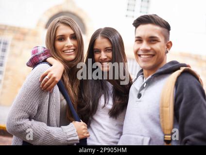 These guys are the best. Portrait of three university students standing together on campus. Stock Photo