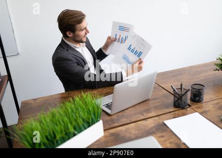 businessman in the office holding a video conference showing graphics on the laptop screen Stock Photo