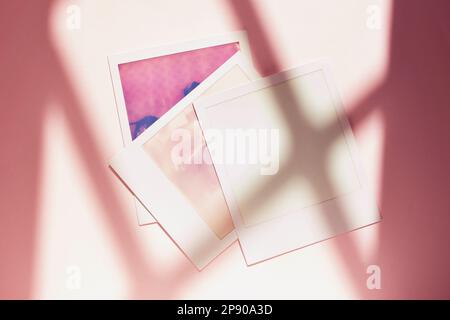 Three instant photos  on colored and lighted background  , vintage polaroid  picture Stock Photo