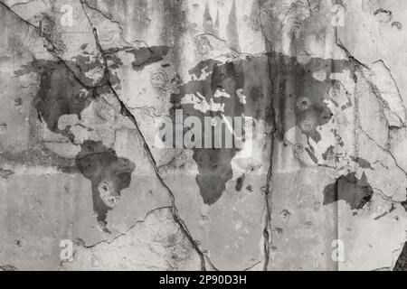 Weathered dark gray world map painted on a cracked wall with bullet holes. High resolution full frame textured background in black and white. Stock Photo