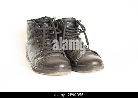 Black leather men's shoes dirty worn on a white background close-up Stock Photo