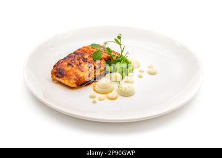 Grilled salmon fillet with sauces next to it on a white porcelain plate Stock Photo