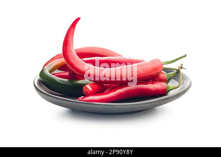 Red chili peppers. Hot spice peppers on plate isolated on the white background. Stock Photo