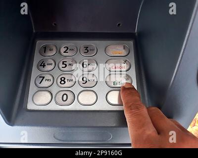 Close up the atm machine number buttons for money withdraw with indonesian money rupiah Stock Photo