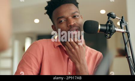 People doing an interview and talking with a mic for podcast. Speaking, broadcast and recording conversation for online streaming in studio. Radio Stock Photo