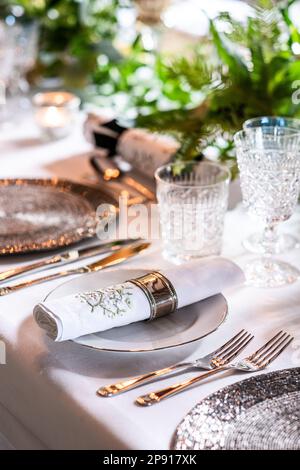 Festive table setting with crystal glasses and plates. Selective focus ...
