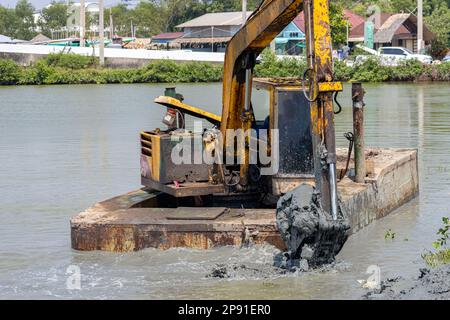 A floating dredger is dredging the bottom of the pond, Thailand Stock Photo