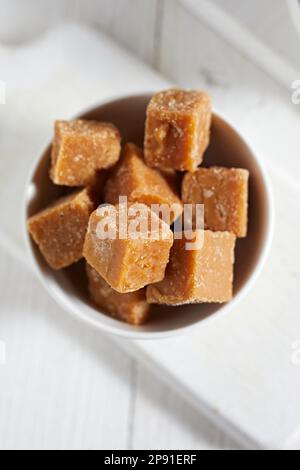 Close up brown cane sugar on white background, selective focus Stock Photo