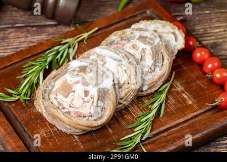 Kokorec. Uncooked kokorec on a wooden serving board. Turkish cuisine delicacies. A dish made from sheep gut Stock Photo