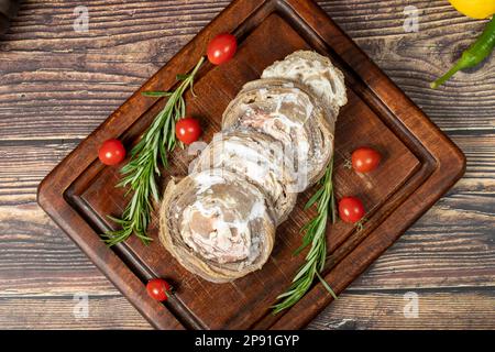 Kokorec. Uncooked kokorec on a wooden serving board. Turkish cuisine delicacies. A dish made from sheep gut. Top view Stock Photo