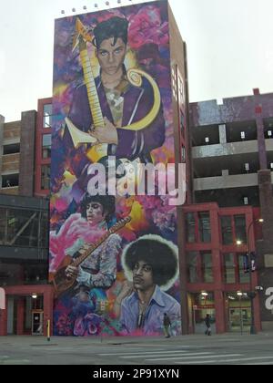A large colorful mural decorates the side of a brick building, depicting abstract shapes and figures in an eye-catching design Stock Photo