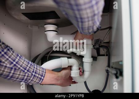 Plumber Fixing Pipe Leak. Broken Kitchen Sink Stock Photo