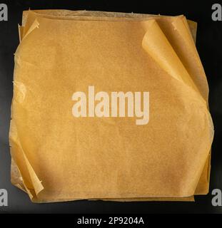 Brown Baking Paper, Kraft Cooking Paper Sheet Texture Background, Bakery Parchment Mockup, Greaseproof Material, Baking Paper on Black Background Top Stock Photo