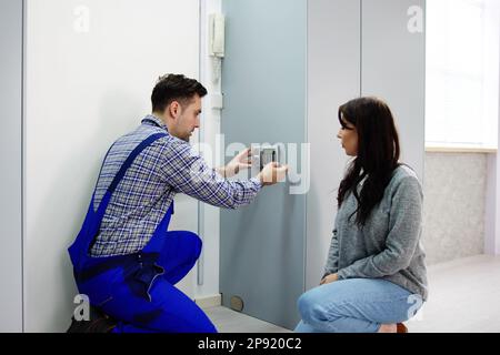 Alarm System Security Installation At Home. Technician Installing Near Door Stock Photo