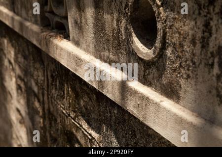 Grey rough dirty wall with drain holes. Geometric textured background with light and shadows on it Stock Photo