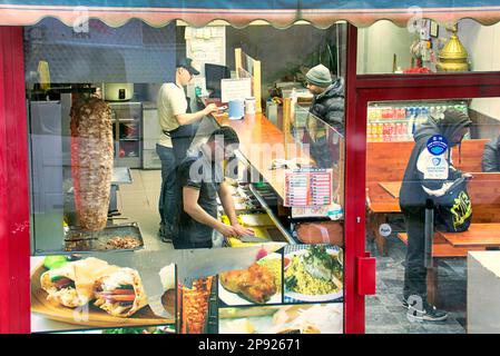 interior of kebab pizza take away fast food premises  viewed from a public street through window Stock Photo