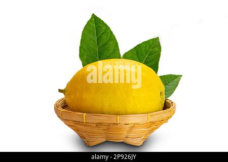 Ripe lemon with leaves in a bammboo basket on white background with clipping path Stock Photo