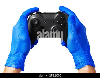 Video game console controller in gamer gloved hands. Games during isolation at home Stock Photo