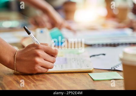 Hands, writing and book for business schedule, planning or brainstorming notes on office desk. Hand in project plan taking note for corporate or Stock Photo