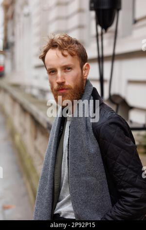 Portrait of a stylish brutal man with a beard posing on a city street Stock Photo
