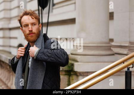 Portrait of a stylish brutal man with a beard posing on a city street Stock Photo