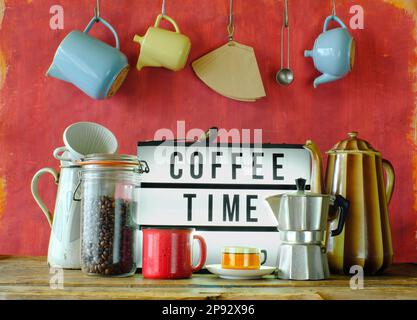 Vintage coffee pots, cups and coffee makers with illuminated sign and slogan Coffee time. Cafe, Restaurant or Coffee  concept Stock Photo