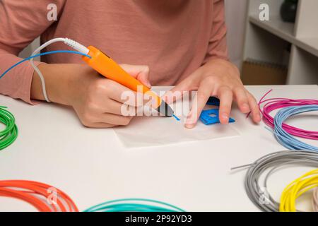 Teen Girl Using 3d Pen. Printing with Colored Plastic Wire Filament. Child making a House, drawing with 3D pen. Artwork, Robotics. STEAM, STEM educati Stock Photo