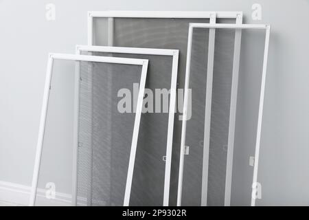 Window Screen Set Designs Set of window screens near light grey wall indoors. Space for text ...