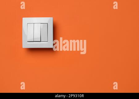 White light switch on orange background. Space for text Stock Photo