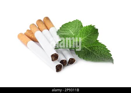 Menthol cigarettes and fresh mint leaves on white background Stock Photo