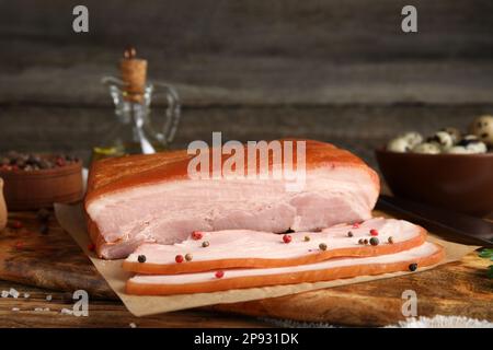 Delicious smoked bacon with spices on wooden table, closeup Stock Photo