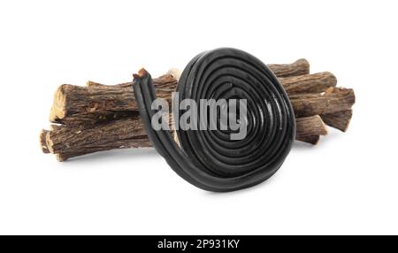 Tasty black candy and dried sticks of liquorice root on white background Stock Photo