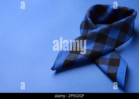 Folded bandana with check pattern on blue background. Space for text Stock Photo
