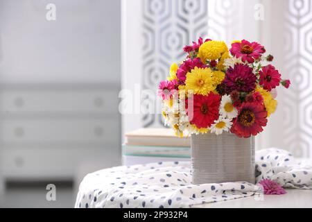Vase with beautiful bouquet and cloth on white table in room. Space for text Stock Photo