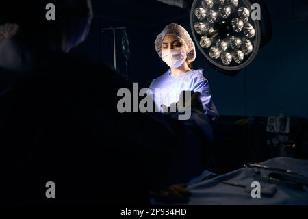 Nurse in an operating uniform stands at the surgical table Stock Photo ...