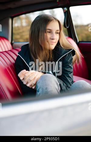 Premium Photo  Serious schoolgirl looking aside while sitting in car