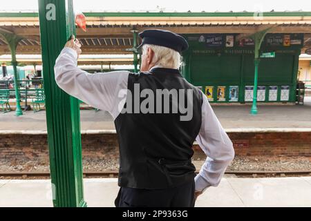 England, Sussex, Bluebell Railway, Horsted Keynes Station, Guard on Station Platform Stock Photo
