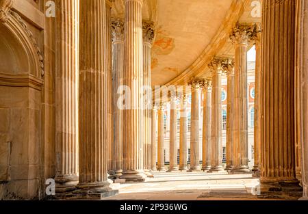 View into the ring-shaped colannades of the Neues Palais in Potsdam with symmetrical columns and Neues Palais in the background Stock Photo