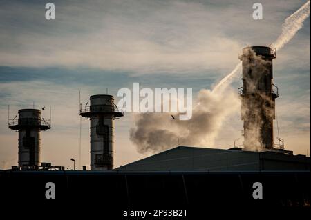 Smoke air emissions  coming from the chimneys of Combined cycle thermoelectric plant Besos Power Station located in Sant Adria del Besos, Barcelona, Spain and owned by Spanish multinational electric utility companies Naturgy and Endesa. Stock Photo