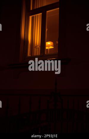 Sparsely lit window of a villa at night Stock Photo