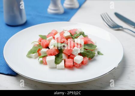 Delicious salad with watermelon, arugula and feta cheese served on white wooden table Stock Photo