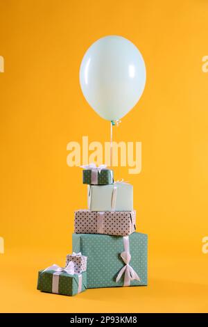 Many gift boxes and balloon on yellow background Stock Photo