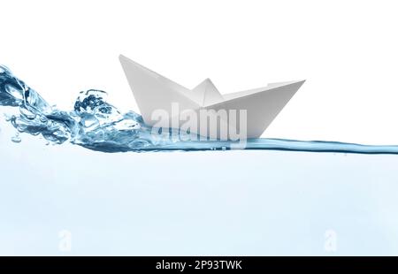 Handmade paper boat floating on clear water against white background Stock Photo