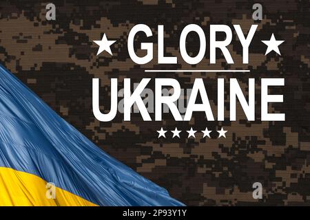 slogan Glory to Ukraine in Ukrainian on waved national flag Stock Photo